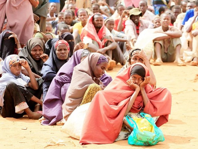 Newly arrived Somali refugees sit in a queue outside a food distribution centre at the Ifo refugee camp in Dadaab in August 2011. / FILE