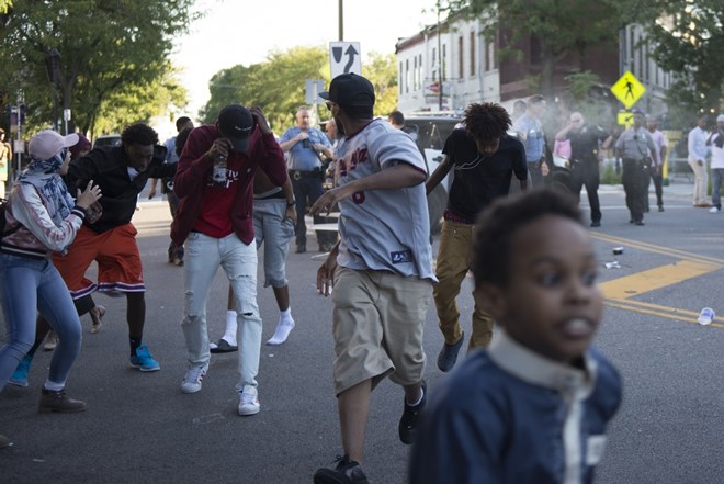 Members of the crowd and protesters flee the event area when officers begin to spray on Saturday, Sept. 10, 2016 in the Cedar-Riverside neighborhood. Photo by: Easton Green