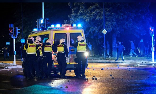 Demonstrators throw stones at police officers during a riot in the Rosengard neighbourhood of Malmo, Sweden August 28, 2020. TT News Agency via REUTERS
