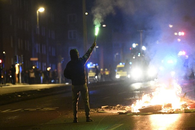 A protestor holds a flare on Malmö's Amiralsgatan street. Photo: TT