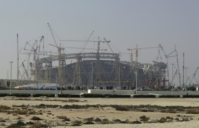 In this Dec. 20, 2019 file photo, construction is underway at the Lusail Stadium, one of the 2022 World Cup stadiums, in Lusail, Qatar. A U.N. labor body says new labor rules in the energy-rich nation of Qatar “effectively dismantles” the country’s long-criticized “kafala” employment system. The International Labor Organization said Sunday, Aug. 30, 2020, that as of now, migrant workers can change jobs before the end of their contracts without obtaining the permission of their current employers. (AP Photo/Hassan Ammar, File)