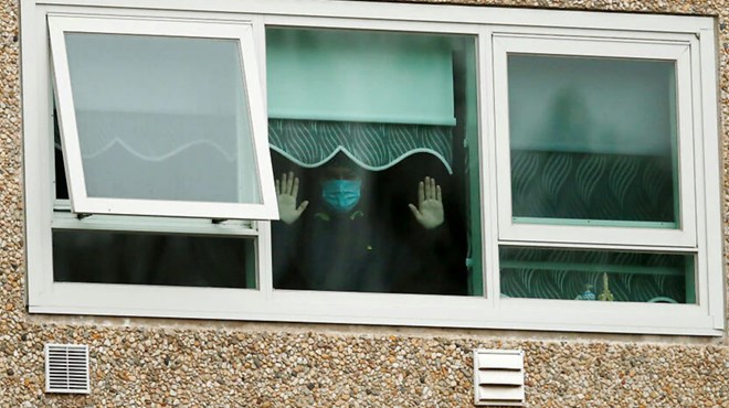 A man is seen looking out a window of the Flemington Towers Government Housing complex. Source: Getty Images