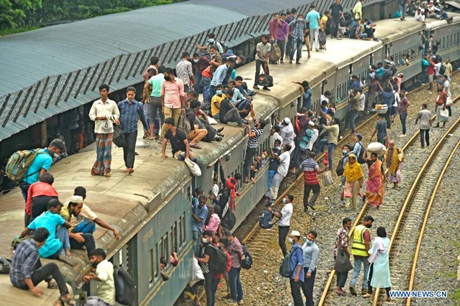 Passengers get onto a packed train at a station in Dhaka, Bangladesh, on July 19, 2021. As Eid al-Adha approaches, hundreds of thousands of Dhaka dwellers have streamed out of the city to join the festival with their kith and kin in village homes. (Xinhua)