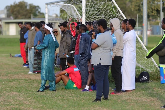 Spectators gather on the sideline to watch teams compete in the Ramadan Cup. (ABC News: Lucas Hill)