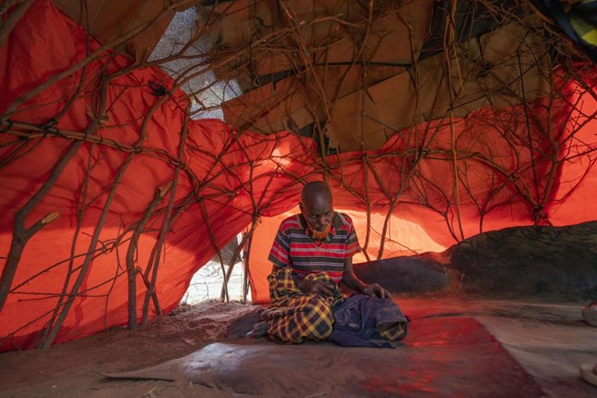 An elder Somali man takes shelter at a camp for displaced people on the outskirts of Dollow, Somalia, Tuesday, Sept. 20, 2022. Somalia has long known droughts, but the climate shocks are now coming more frequently, leaving less room to recover and prepare for the next. (AP Photo/Jerome Delay)