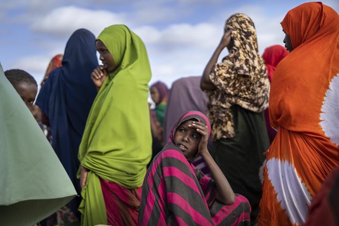 Somali women wait their turn to collect water at a camp for displaced people on the outskirts of Dollow, Somalia on Monday, Sept. 19, 2022. Somalia has long known droughts, but the climate shocks are now coming more frequently, leaving less room to recover and prepare for the next. (AP Photo/Jerome Delay)