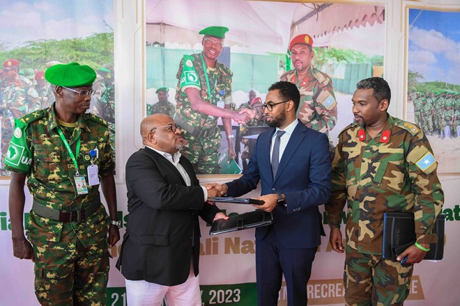The Special Representative of the Chairperson of the African Union Commission (SRCC) for Somalia, Ambassador Mohammed El-Amine Souef (second from left) and Somalia's State Minister of Defense Abdinur Dahir Fidow (second from right) exchange handover documents during the official handover of Maslah Forward Operating Base (FOB) in Mogadishu, Somalia, on 21 January 2023. ATMIS Photo / Mukhtar Nuur