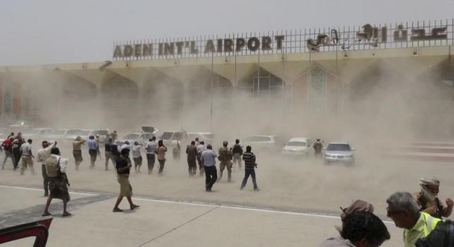 People seek cover from rising dust as a Qatari military cargo plane carrying aid lands at the international airport of Yemen's southern port city of Aden August 1, 2015.
REUTERS/STRINGER