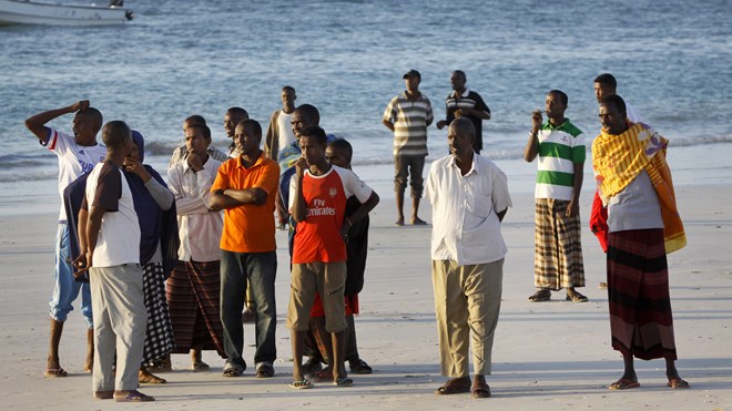 Somalis wait on the beach for news and to collect the bodies of their relatives following an overnight attack on a beachfront restaurant in Mogadishu, Somalia, Friday, Jan. 22, 2016. Somalia's security forces ended a deadly siege of a beachfront restaurant in the capital, with many killed in the attack, a police official said Friday.