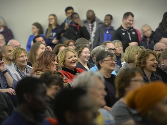 A packed crowd of audience members share a laugh as Somali community member Lul Hersi humorously describes an example of how she has assimilated into the community by helping her young children fill out countless Valentine's Day cards over the years. (Photo: Kimm Anderson)