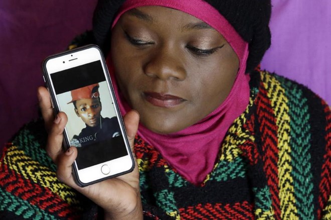 Abdi Mohamed's cousin Muslima Weledi holds a photograph of him during a interview Thursday, March 3, 2016, Salt Lake City. Mohamed, a 17-year-old Somali refugee critically wounded in a high-profile police shooting in Utah fled to the U.S. from a refugee camp where food was scare, scorpions scurried everywhere and a toilet was a hole in the ground. Mohamed’s family settled in Salt Lake City, hoping for a better life. (AP Photo/Rick Bowmer)