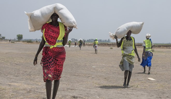 Women walk back to their homes after receiving food distributed by the International Committee of the Red Cross in South Sudan. (Associated Press/ )