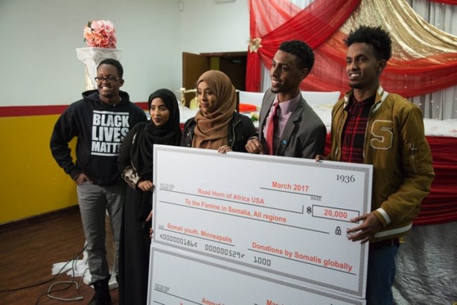 Kali Mohamed, Hafsa Jibril, Nadira Mohamed and Liban Adam (left to right) hold up a giant check for Read Horn of Africa USA, one of three organizations for which they raised money. The other two organizations are Amoud Foundation and CaaliWalaal, which means “Help Your Brother” in Somali. Credit: Arthur Nazaryan/PRI