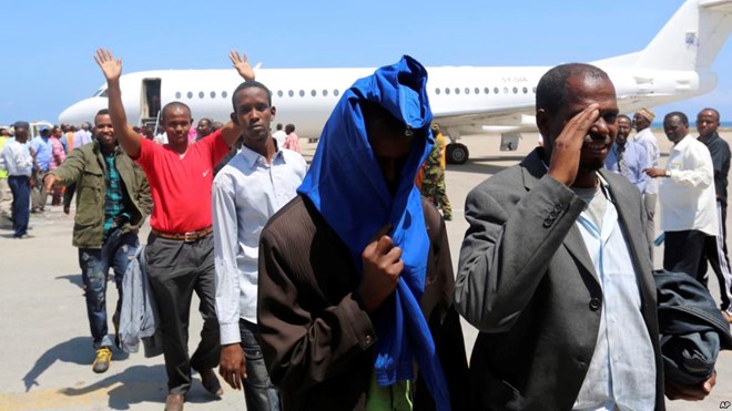 FILE- Deported Somali nationals gesture as they arrive at the airport in Somalia's capital of Mogadishu, April 9, 2014. Sixty-eight Somalis arrived in Magodishu Friday, having been deported by U.S. immigration authorities.