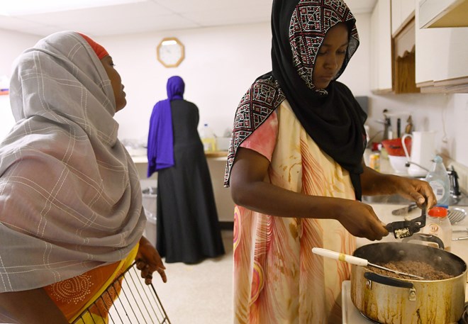 Women prep deep-fried sambusas at the Viles Arboretum kitchen in Augusta for the Beyond Borders Farmers Market. Khadija Hussein, left, Asli Hassan and Farhiya Ibrahim serve the traditional Somali food at the market run by refugees who have resettled in Maine. Staff photo by Andy Molloy