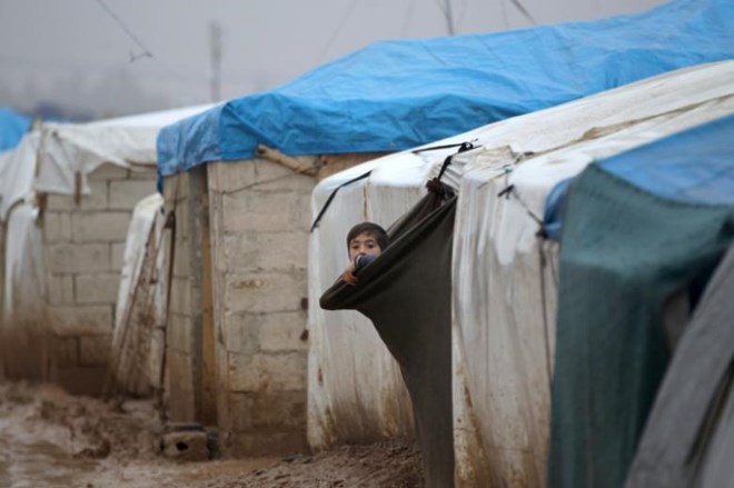 FILE PHOTO - An internally displaced Syrian boy looks out his tent in the Bab Al-Salam refugee camp, near the Syrian-Turkish border, northern Aleppo province, Syria December 26, 2016. REUTERS/Khalil Ashawi
