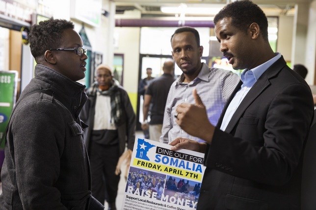 Khalid Mohamed, from left, hands out flyers to Faysal Ali and Muhiadin Mohamud to raise awareness for Dine Out for Somalia at the Village Market mall in Minneapolis.
