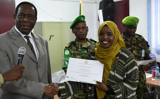 Ambassador Francisco Madeira, the Special Representative of the Chairperson of the African Union Commission (SRCC) for Somalia, presents a certificate to a female participant during the closing session of a two-day seminar on Countering Improvised Explosive Devices (CIEDs) in Mogadishu, Somalia, on 17 April 2018. AMISOM Photo / Omar Abdisalan