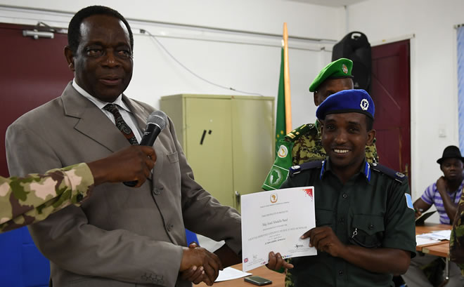 Ambassador Francisco Madeira, the Special Representative of the Chairperson of the African Union Commission (SRCC) for Somalia, presents a certificate to a Somali Police Force officer during the closing session of a two-day seminar on Countering Improvised Explosive Devices (CIEDs) in Mogadishu, Somalia, on 17 April 2018. AMISOM Photo / Omar Abdisalan