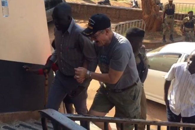 Mr Jimmy Taylor (right) after Ugandan police arrested him on August 18, 2018 after viral video showed him assaulting hotel workers in Kampala. PHOTO | TWITTER
