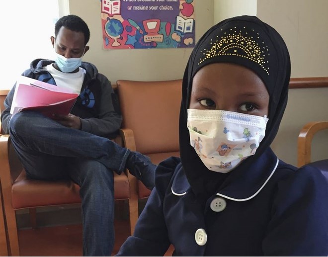In this 2017 photo, Amira Hassan, of Burnsville, Minn., plays in the waiting room at the specialty clinic at Children's Minnesota in Minneapolis, while her dad, Mohamud Hassan, fills out paperwork. A year after a measles outbreak, the vaccination rates in Minnesota have increased 16 percentage points among Somali-American children. Amy Forliti | AP