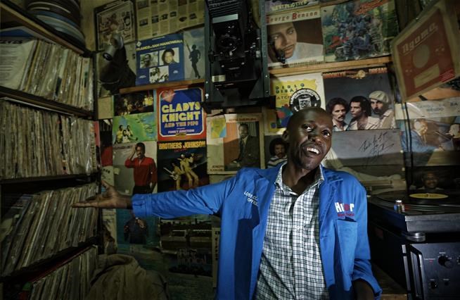 In this photo taken Thursday, March 1, 2018, Ndegwa, 33, stands inside the vinyl records stall of his father James "Jimmy" Rugami, where he works in Kenyatta Market in Nairobi, Kenya.   (AP Photo/Ben Curtis)