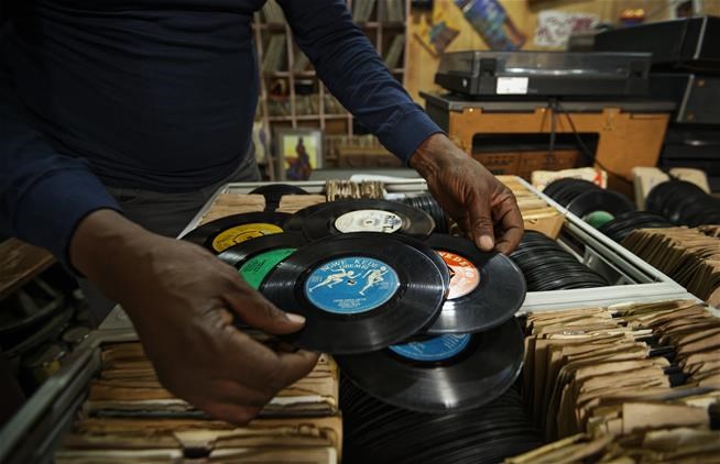 In this photo taken Thursday, March 1, 2018, James "Jimmy" Rugami shows records inside his vinyl records stall in Kenyatta Market in Nairobi, Kenya.   (AP Photo/Ben Curtis)