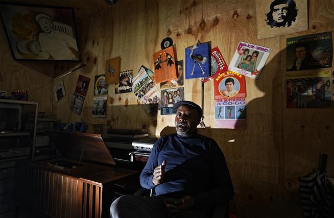 In this photo taken Thursday, March 1, 2018, James "Jimmy" Rugami recounts his story inside his vinyl records stall in Kenyatta Market in Nairobi, Kenya.   (AP Photo/Ben Curtis)
