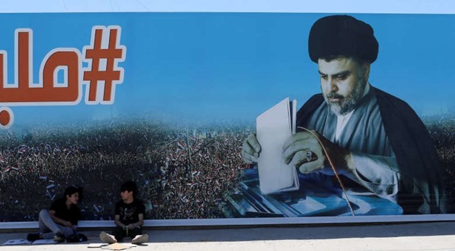 Boys sit next a poster of Sadr in the Sadr City district of Baghdad on Saturday. (Thaier al-Sudani/Reuters)