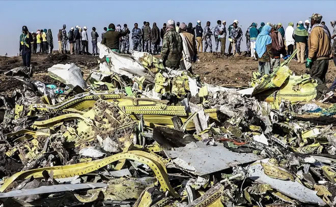 People stand near debris at the crash site of the Ethiopia Airlines flight in Ethiopia, on March 11, 2019. MICHAEL TEWELDE/AFP/Getty Images